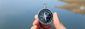 hand holding a compass with background blurred